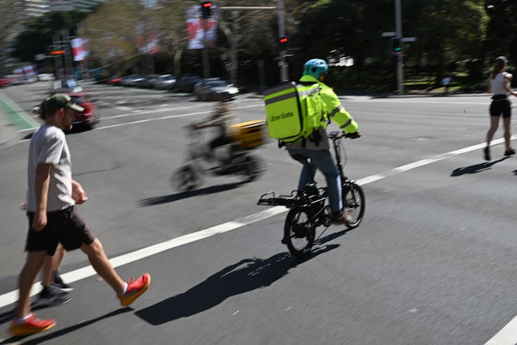 A delivery driver rides a bicycle